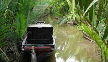 Boat in a stream on Cồn Tàu (Ship Island) in the Mekong Delta.