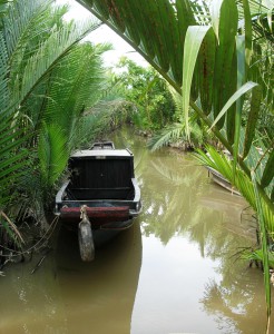 Boat in a stream on Cồn Tàu (Ship Island) in the Mekong Delta.