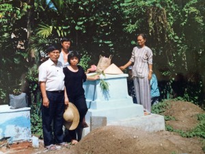 Family members getting ready to move Grandfather's grave. Around them graves have already been removed.