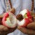 Lượng’s mother holding a rose red bellfruit she split open. The spongy flesh inside holds seeds.