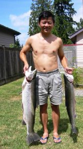 Luong with a steelhead trout in each hand.